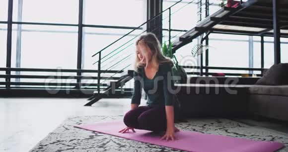 伸展身体和腿部瑜伽姿势女士在她的公寓里为健康的生活方式在早上练习瑜伽视频的预览图