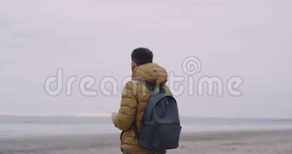 游客带着一个包来到爱尔兰海滩的一个美丽的地方他给人留下了深刻的印象拍照留念视频的预览图