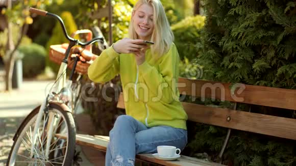 喝咖啡的博客阳光明媚的秋日公园里快乐的年轻女子关于博客早咖啡的概念视频的预览图