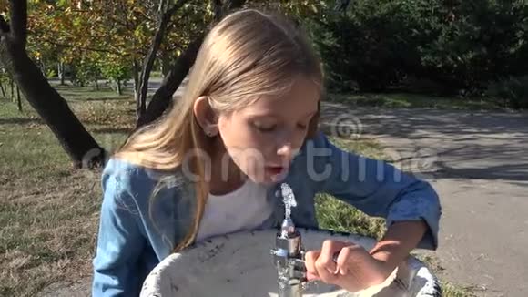 公园公共喷泉中的儿童饮水小女孩玩水视频的预览图