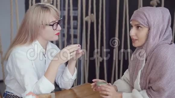 两位不同民族传统的妇女一起在自助餐厅休息视频的预览图