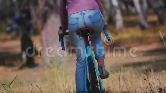 年轻迷人的女人下班后骑着车穿过公园日落时美丽的女士骑自行车自行车作为时尚视频的预览图