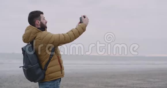 在爱尔兰年轻人高兴地来到了一个美丽的地方在一个大海滩上有海景游客在拍照视频的预览图