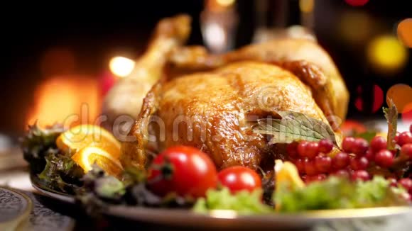 在燃烧的壁炉和发光的灯光下在圣诞餐桌上播放最新出炉的火鸡的最新慢动作视频视频的预览图