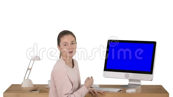 迷人的女人在电脑屏幕上展示一些东西与相机交谈白色的蓝色屏幕模拟显示视频的预览图