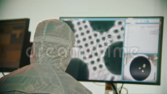 一名身穿白色防护服的男工坐在监视器旁宇宙研究实验室视频的预览图