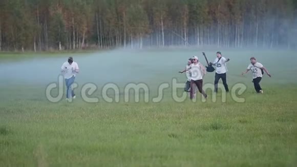 一群摇滚乐手在烟雾弥漫的田野里玩着工具的乐趣有趣的镜头视频的预览图
