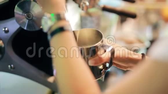 咖啡师将热牛奶倒入钢杯视频的预览图