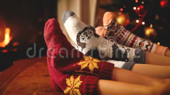 在圣诞节或新年期间一对夫妇躺在壁炉旁穿着温暖的羊毛袜视频的预览图