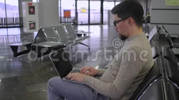 在机场大厅里男人正在用键盘打字视频的预览图