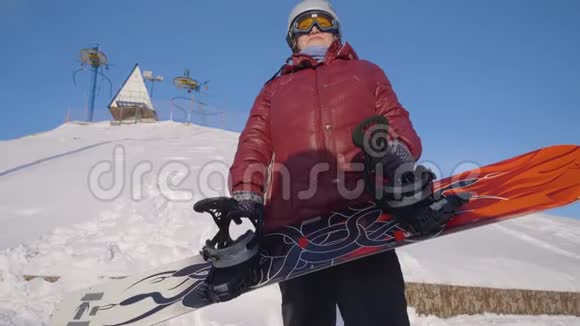 年长的女人拿着滑雪板下面是一位戴头盔戴眼镜身穿滑雪服站在里面的老年妇女视频的预览图