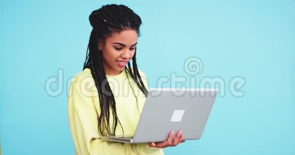 可爱的非洲女人带着可怕的家伙在她的笔记本上工作她双手抓着看上去非常集中在一个视频的预览图