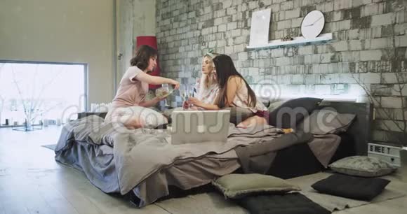 充满魅力的微笑的女士有一个家庭聚会在一个现代化的卧室里她们喝香槟欢呼拥抱在一起视频的预览图