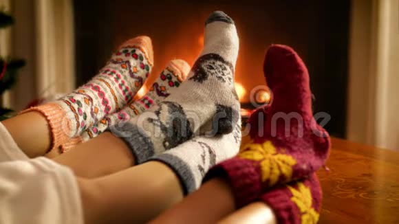 特写4k镜头一家人穿着羊毛袜子双脚挨着壁炉人们在冬天放松视频的预览图