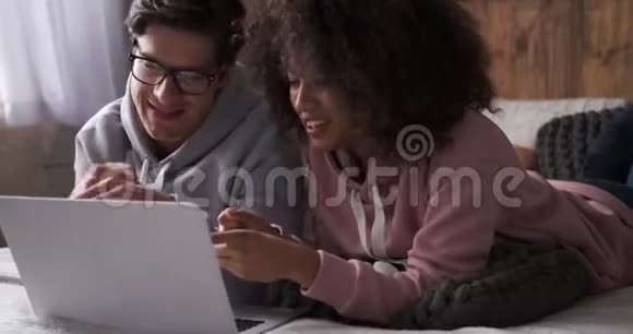 情侣们玩着看笔记本电脑上的媒体内容视频的预览图