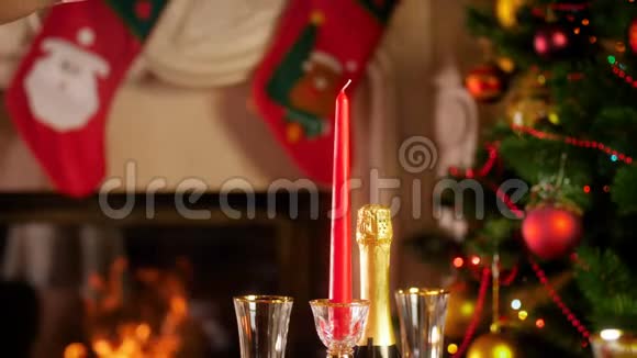 4k镜头女性用火柴点燃蜡烛燃烧的壁炉和发光的圣诞树用餐视频的预览图