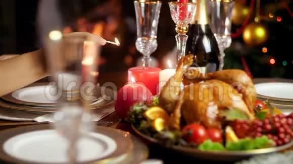 4k视频的妇女点燃蜡烛在桌子上为圣诞节或新年晚餐提供丰盛的餐桌视频的预览图