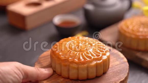 女人把漂亮的月饼糕点放在桌子上吃庆祝中秋节活动服务概念视频的预览图