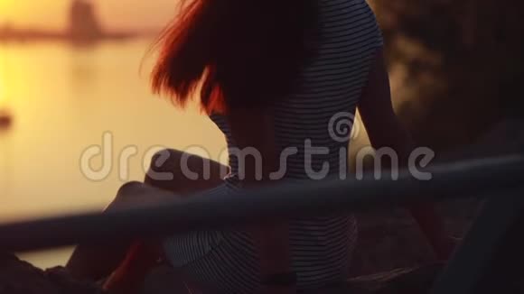 女人坐着放松看日落的剪影视频的预览图