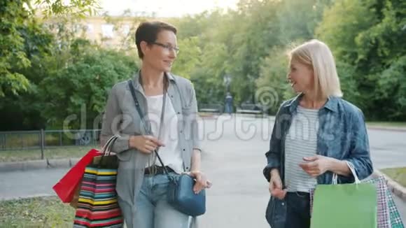 秋日美丽的女人拿着纸袋在街上散步视频的预览图