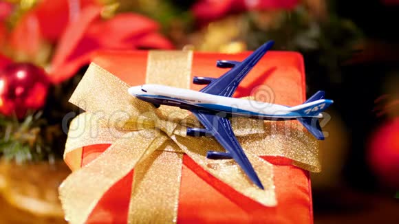 特写4k镜头的小玩具飞机在圣诞礼品盒与发光和闪闪发光的圣诞灯概念视频的预览图