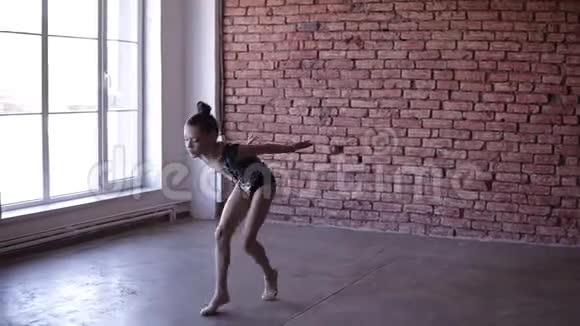 漂亮的女孩在窗户附近用艺术体服跳舞艺术体操体操运动的年轻体操运动员视频的预览图