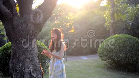 美丽的亚洲女孩在阳光下微笑视频的预览图