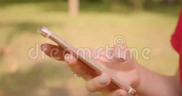 夏季公园户外使用手机的白种人年轻女性手的特写照片视频的预览图