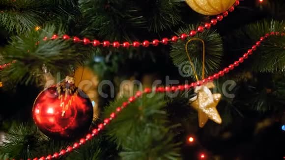 特写4k镜头镜头沿着圣诞树树枝移动上面有珠子球玩具和光环视频的预览图