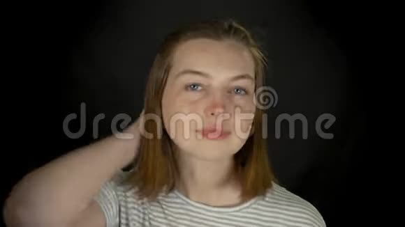 年轻的白种人长发女孩在黑工作室照镜子视频的预览图