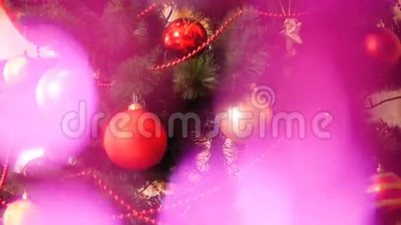 特写4k抽象视频闪闪发光的粉红色花环在装饰圣诞树前完美的镜头视频的预览图