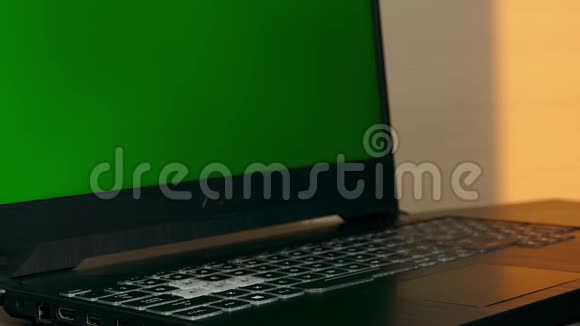 手拿着绿色屏幕的笔记本电脑键盘等待视频的预览图