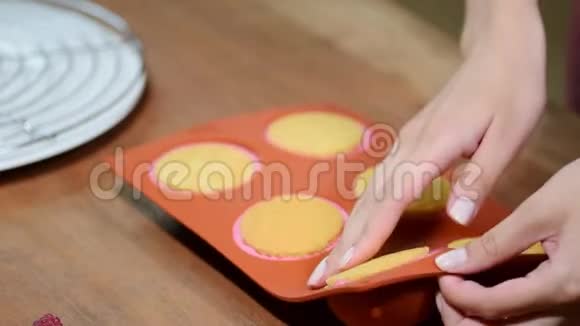 女性手拿方慕斯蛋糕从一个灵活的硅胶模具特写视频的预览图