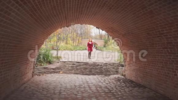 穿红裙子的女孩在公园里散步视频的预览图