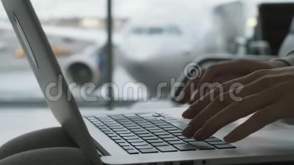 在机场大厅工作的女性手提电脑在窗口等待登机视频的预览图