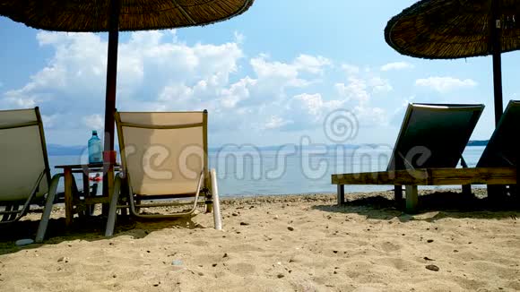 威克海滩遮阳伞和日光浴在美丽的沙滩上蓝天少云希腊哈尔基迪基视频的预览图
