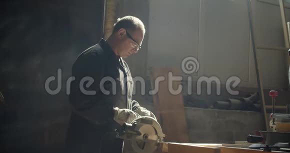 高级男性师傅在制造中打磨木板的轮廓镜头视频的预览图