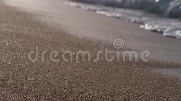 光着脚的女人走在潮湿的沙滩上视频的预览图