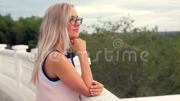 一个欧洲可爱的金发女郎向远处望去一个年轻快乐的女人或一个享受大自然的快乐女孩的肖像视频的预览图