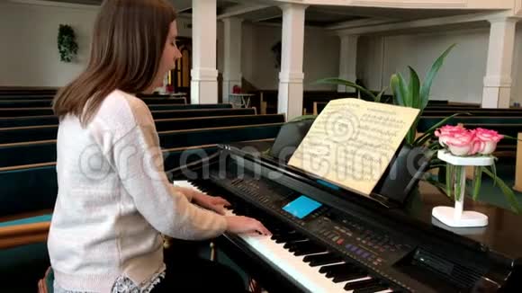 坐在钢琴旁学习音乐的女孩视频的预览图