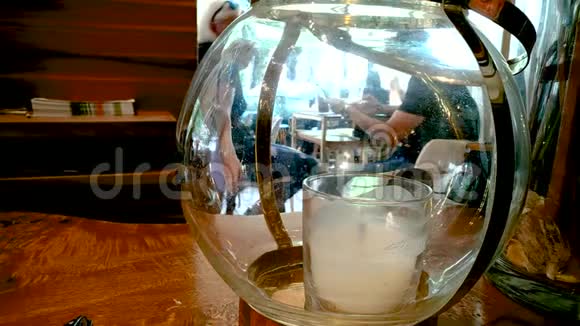 有蜡烛的玻璃器皿在它后面人们谈论和喝咖啡视频的预览图
