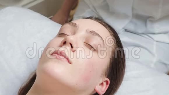 深色头发的女人在沙龙接受面部按摩视频的预览图