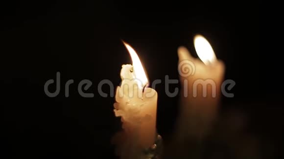 在黑暗的房间里近距离观看明亮燃烧的蜡烛在黑暗中点燃蜡烛温暖舒适的气氛视频的预览图