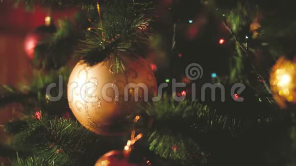 圣诞前夜圣诞树上挂着球花环和灯的特写镜头完美的镜头视频的预览图