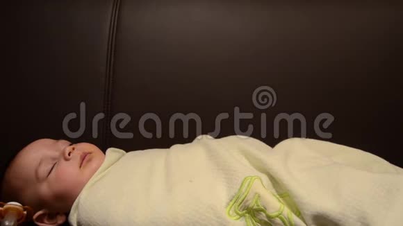 六个月大婴儿睡觉时用毯子裹着的镜头视频的预览图