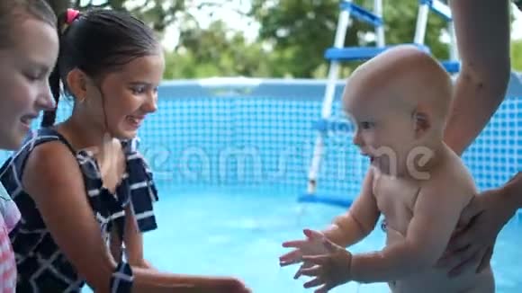 两个十几岁的妹妹和弟弟在游泳池里玩给他喝点水一岁小孩洗澡视频的预览图