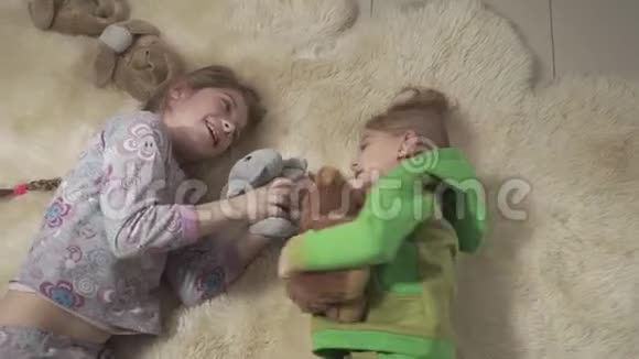 小兄弟在毛茸茸的地毯上滚动兄弟姐妹玩得开心孩子们周末快乐慢动作视频的预览图