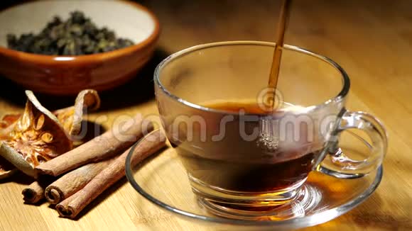 在装有蒸汽的杯子中倒入红茶或热草饮料视频的预览图