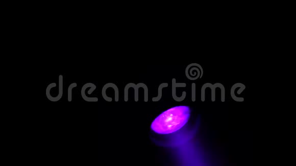 一盏探照灯会在黑色背景上用彩色光束照射视频的预览图