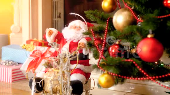 特写4k镜头圣诞老人娃娃在装饰圣诞树旁边的壁炉在客厅完美的镜头视频的预览图